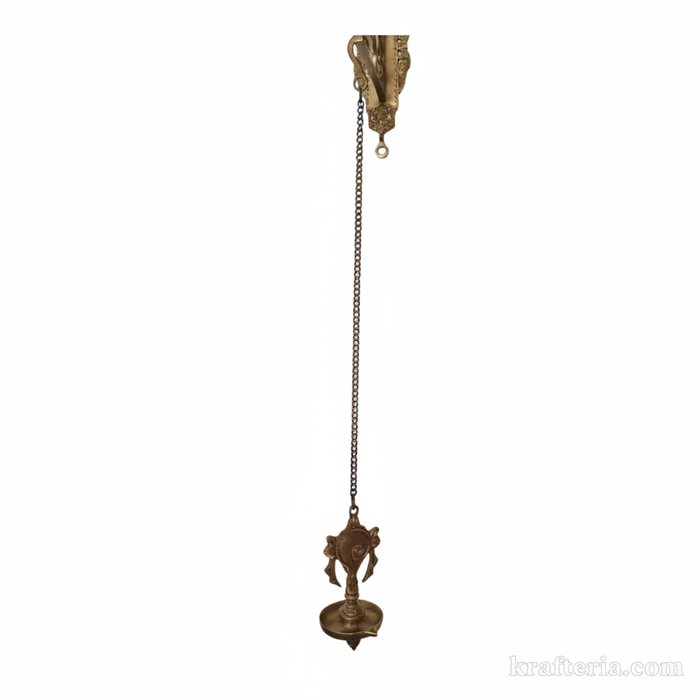 Antique brass diya wall hanging featuring shankh and chakra motifs, an oil lamp for spiritual home decor.