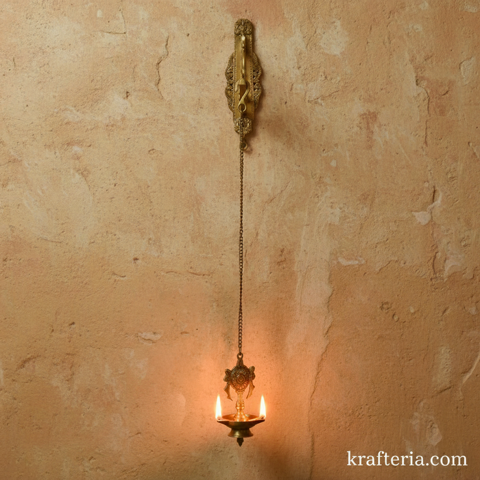 Antique brass diya with shankh and chakra design, a spiritual wall hanging oil lamp for home decor.