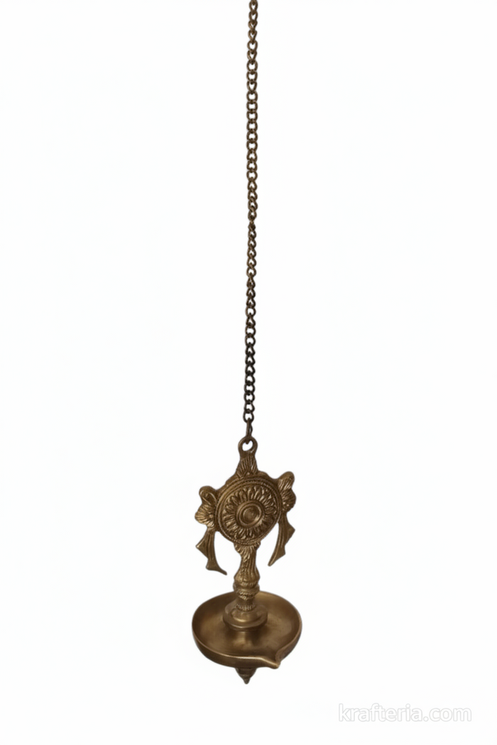 Antique brass diya wall hanging featuring shankh and chakra design, a spiritual home decor oil lamp.
