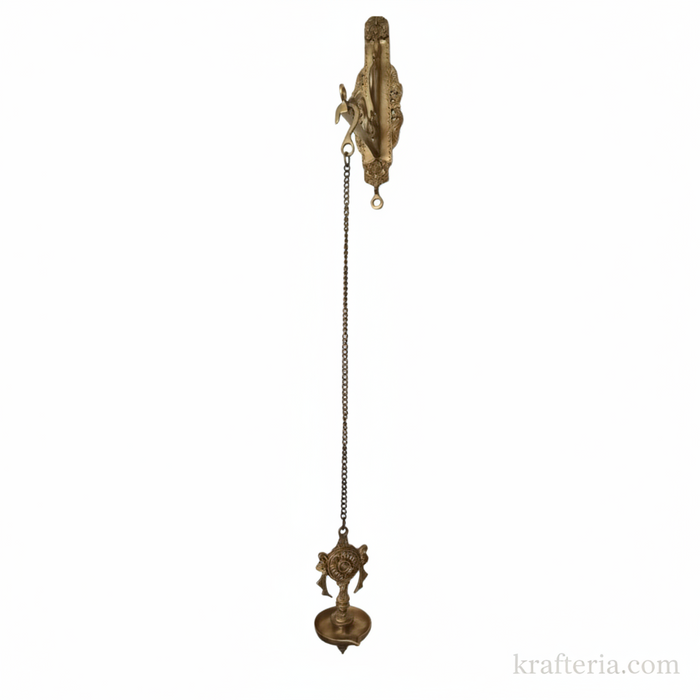 Antique brass diya wall hanging with shankh and chakra design, an oil lamp for spiritual home decor.