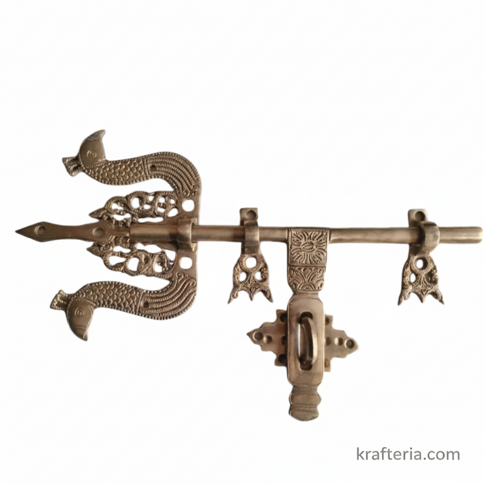 Antique brass door latch with Trishul design, a traditional decorative door bolt.