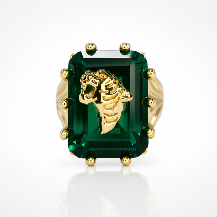 Gold ring with a large green gemstone on a white background
