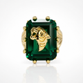 Gold ring with a large green gemstone on a white background