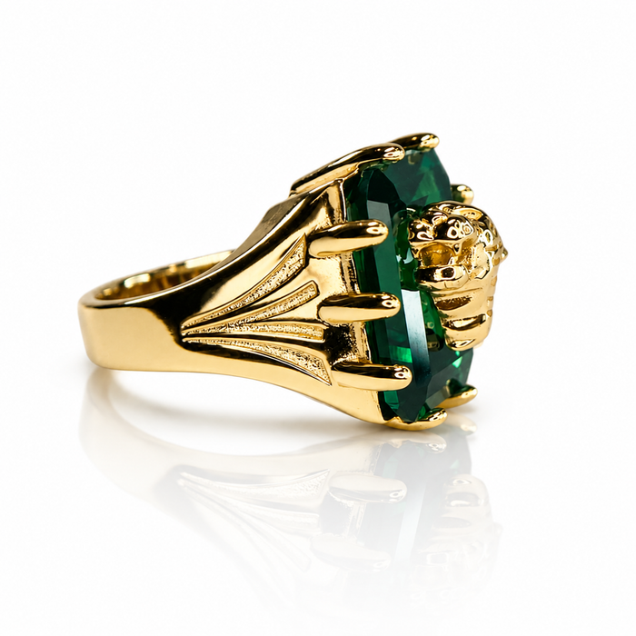 Gold ring with a green gemstone on a white background