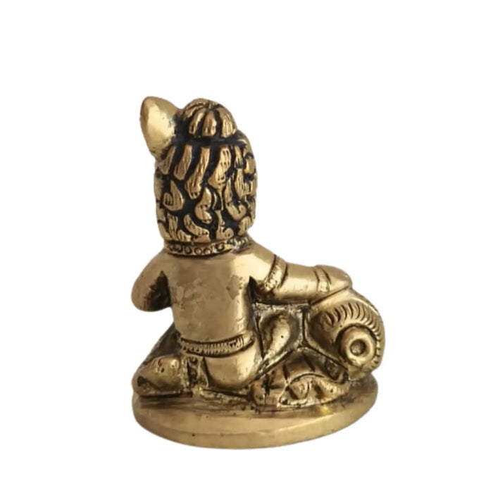 Brass Bal Krishna idol holding a butter ball, crafted from brass ware.