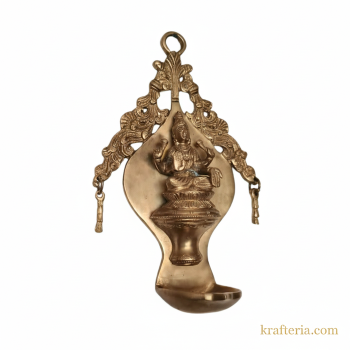 Brass Lakshmi diya wall hanging with ornate arch, traditional oil lamp.