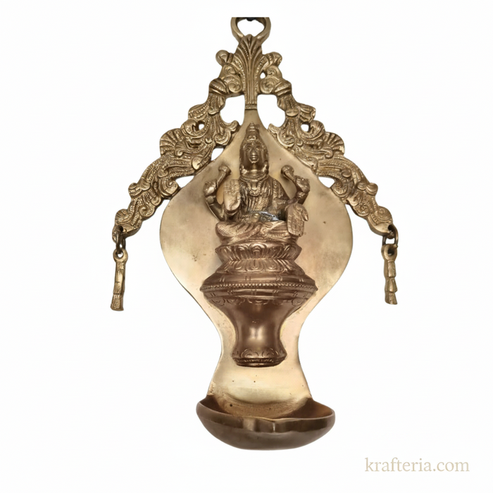 Brass Lakshmi diya wall hanging, traditional ornate oil lamp.