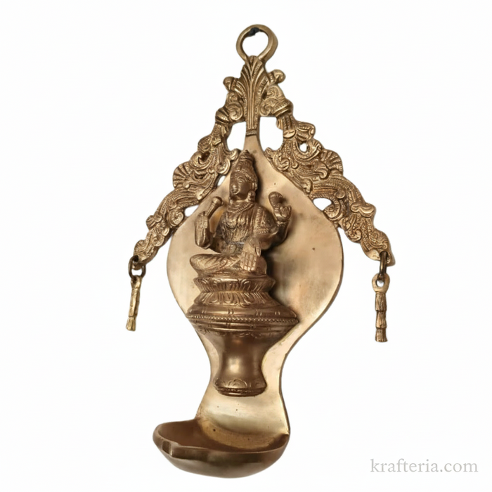 Brass Lakshmi diya wall hanging, ornate arch oil lamp.