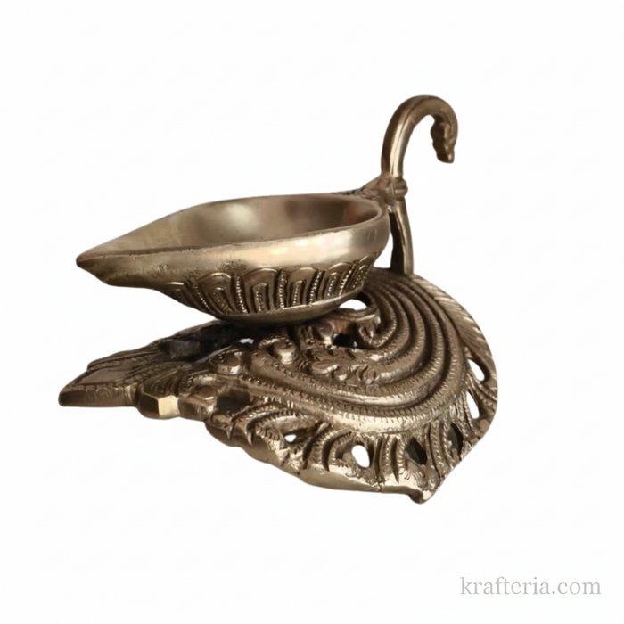 Intricate brass diya lamp with decorative swan handle, traditional Indian oil lamp.