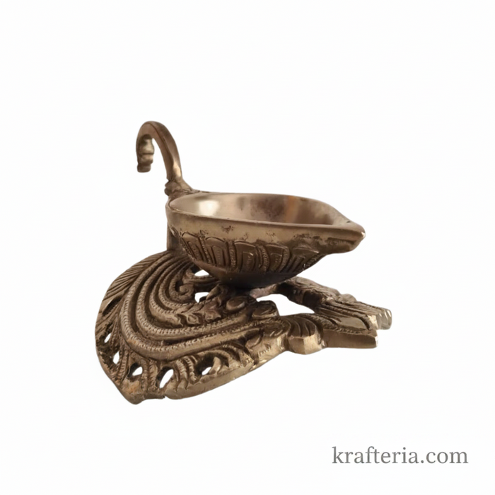 Ornate brass diya lamp with swan handle, a traditional oil lamp for rituals.