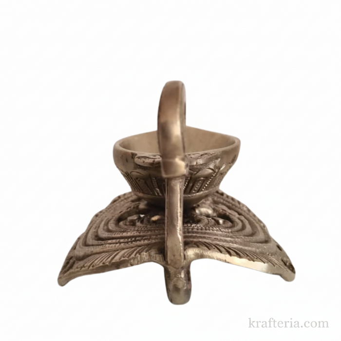 Ornate brass diya lamp with decorative swan handle, a traditional oil lamp.