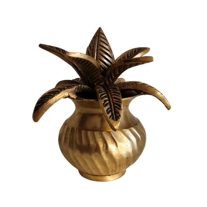 Detailed brass kalasha with lotus leaves, a traditional brass water pot.