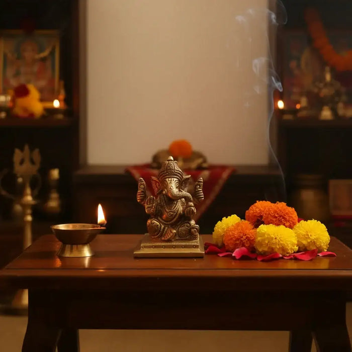 Miniature Lord Ganesha idol in brass, four-armed, symbol of success and wisdom.