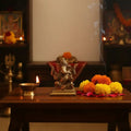 Miniature Lord Ganesha idol in brass, four-armed, symbol of success and wisdom.