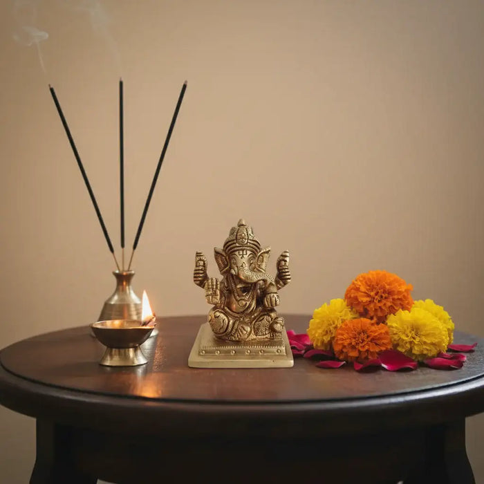 Miniature Lord Ganesha idol in brass, four-armed, symbolizing success and wisdom.