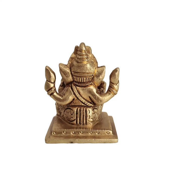 Miniature Lord Ganesha idol, four-armed brass figure, symbol of success and wisdom.