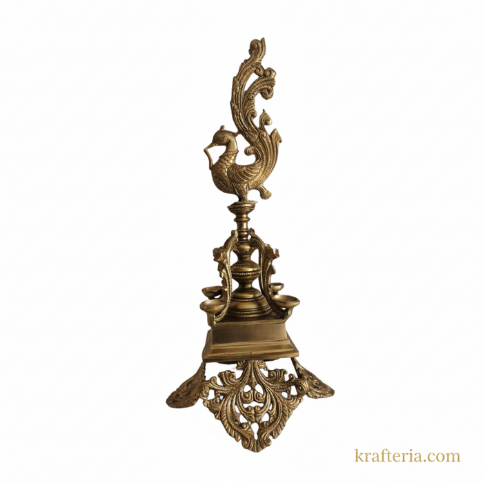 Ornate brass peacock diya with four wicks, a beautiful decorative oil lamp.