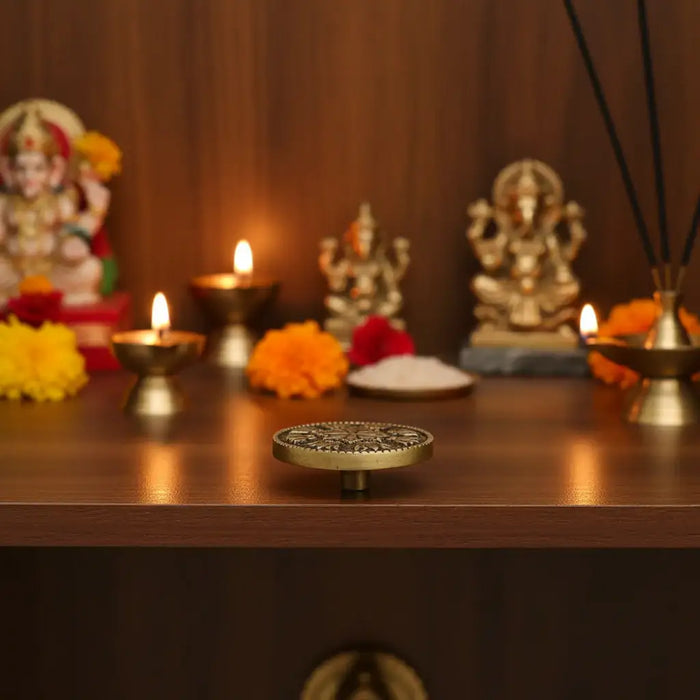 A round brass pedestal stand, a brass ware ritual holder.