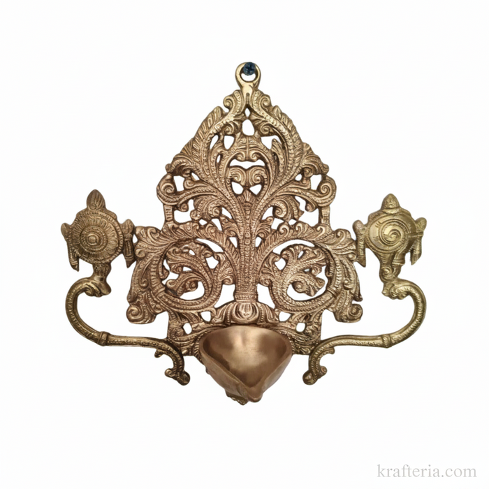 Traditional brass shankh chakra diya lamp with intricate filigree detail.