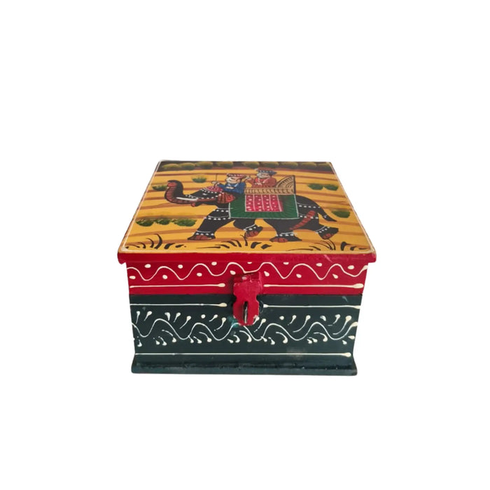 Multicolor wooden jewellery box with a hand-painted lid showing a royal procession on an elephant on a yellow background, and red and dark green sides with white decorative patterns, featuring a red latch.