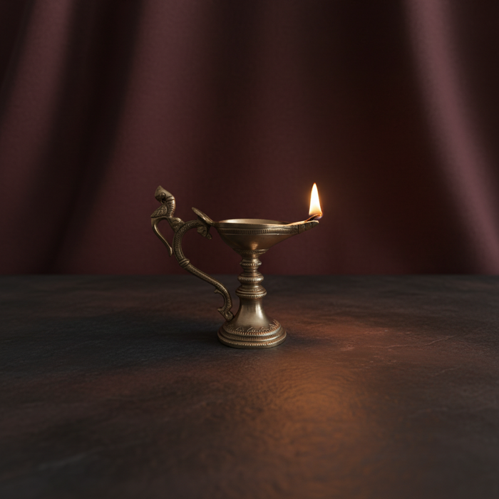 Handcrafted hanging peacock diya, a traditional brass oil lamp.