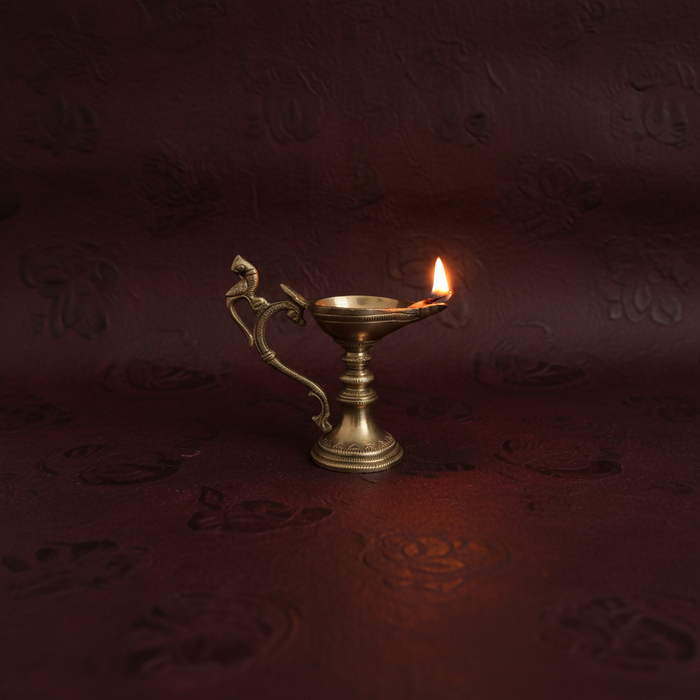 Handcrafted hanging peacock diya, a traditional brass oil lamp for decoration.