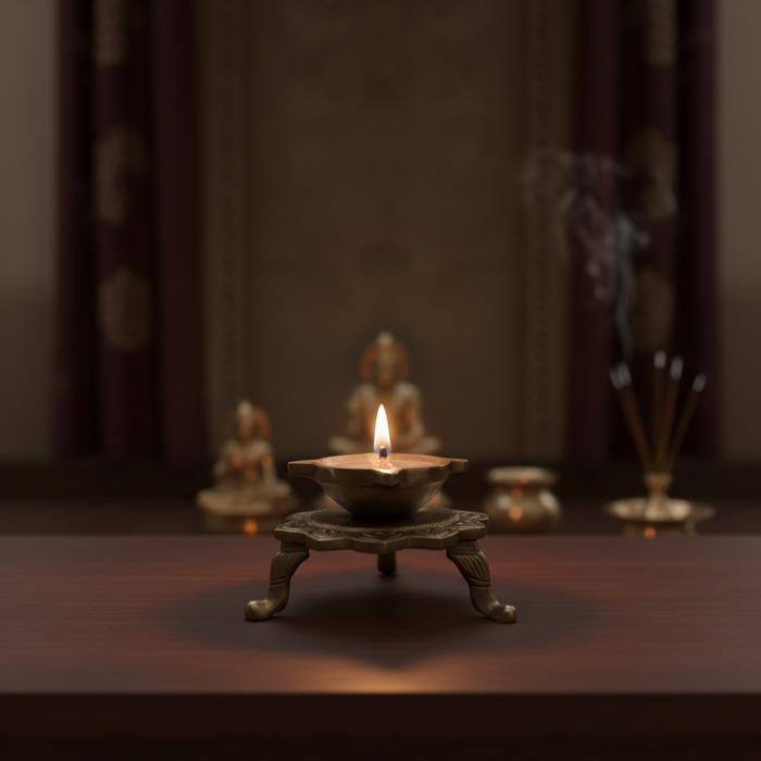 Handcrafted brass lotus diya with ornamental legs, a traditional tabletop oil lamp.