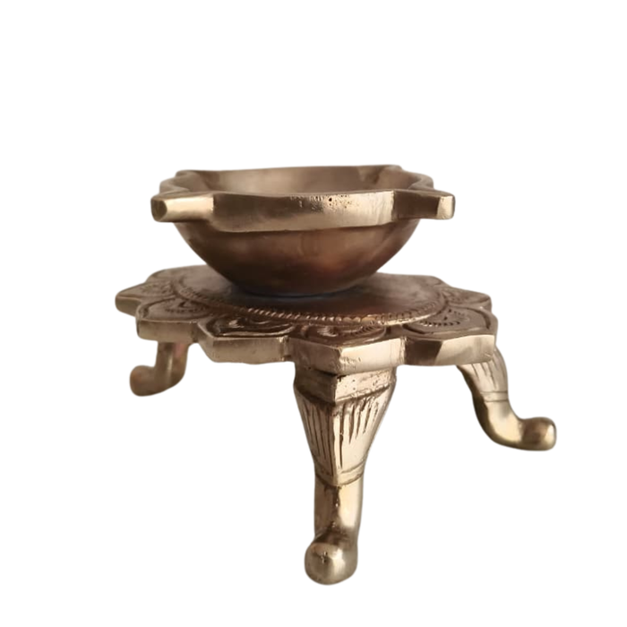 Ornate brass lotus diya tabletop oil lamp with decorative legs.
