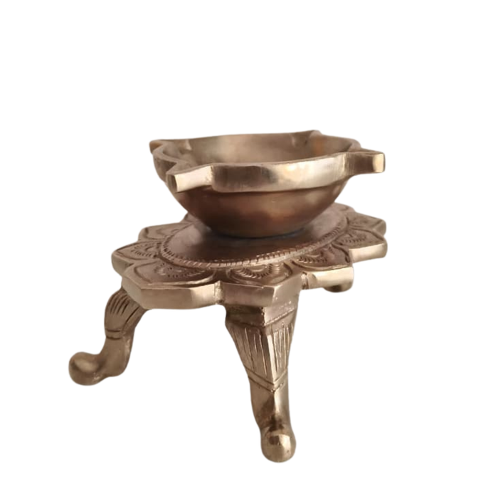Brass lotus diya on ornamental legs, a traditional handcrafted tabletop oil lamp.
