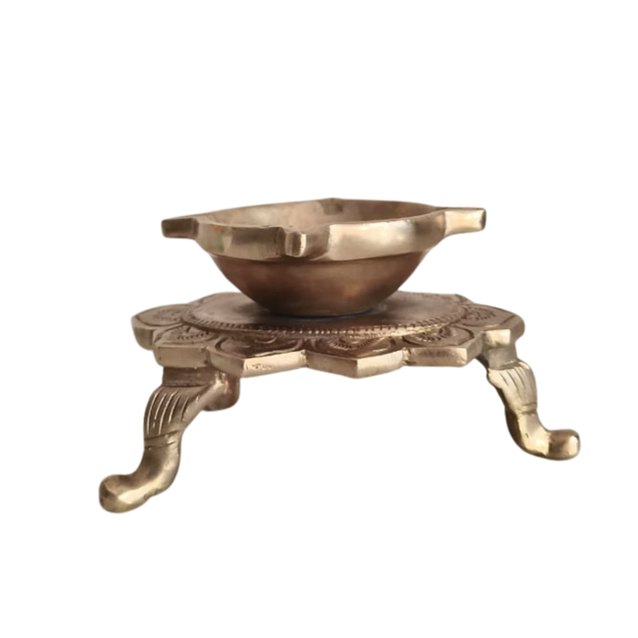 Handcrafted brass lotus diya, ornate tabletop oil lamp with decorative legs.