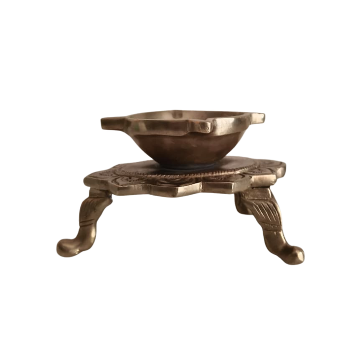 Brass lotus diya on ornamental legs, a handcrafted traditional tabletop oil lamp.