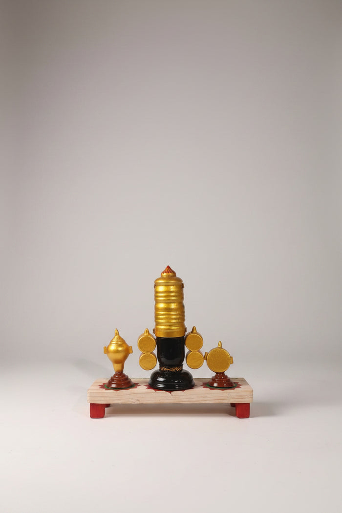Lord Venkateswara wooden altar with golden crown, conch, and chakra wheels on a decorated base