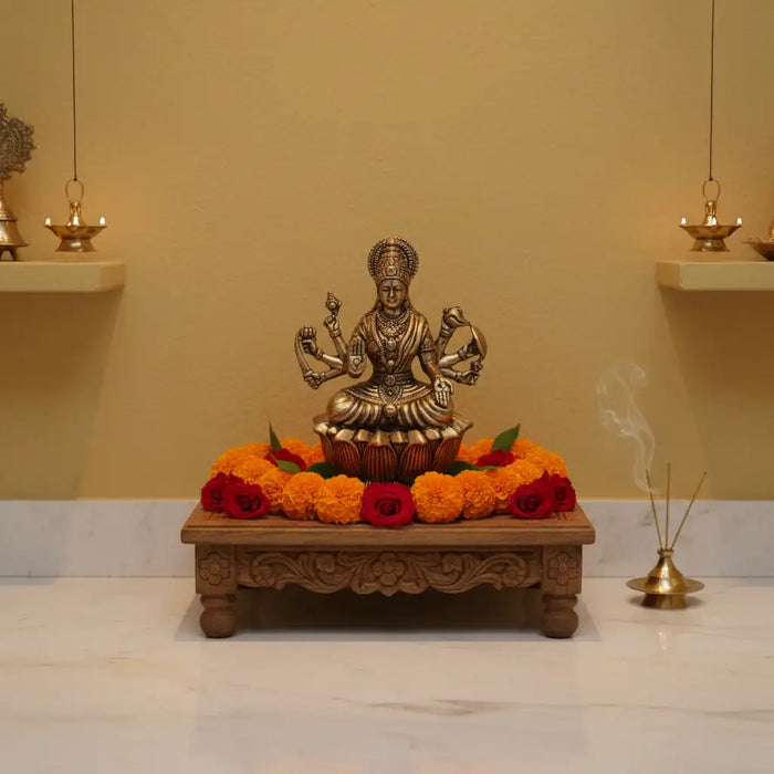 Brass Mahalakshmi eight arms idol seated on a lotus base.