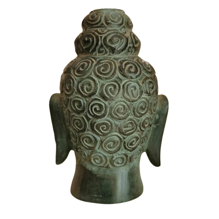 Artisan-carved marble Buddha face with tranquil features.