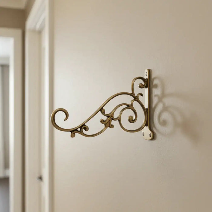 Ornate antique brass wall bracket for hanging decorative items.