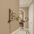 Ornate antique brass wall bracket for hanging items.