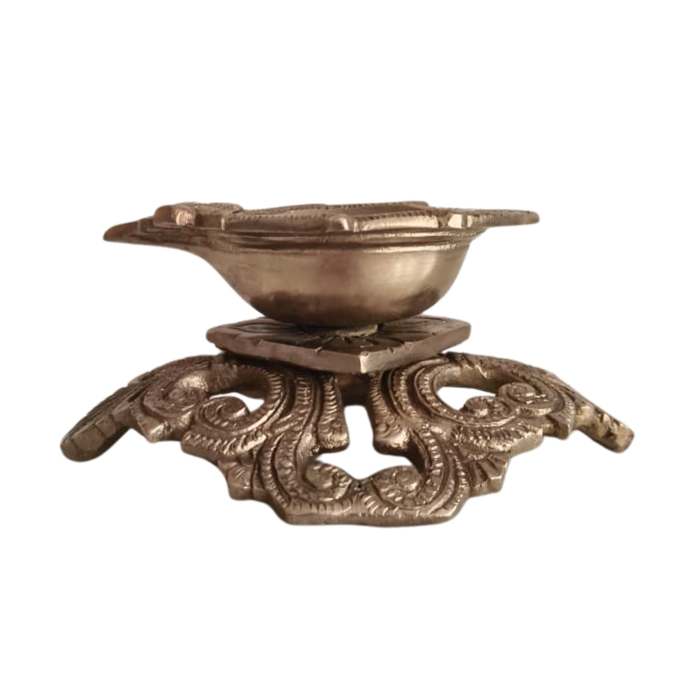 Ornate pedestal diya, a handcrafted brass traditional oil lamp, showcases intricate decorative details.