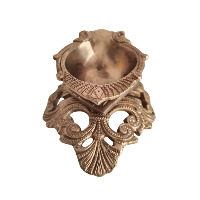Ornate pedestal diya, a handcrafted brass oil lamp, intricate traditional design.