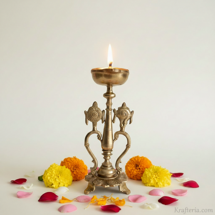 Sacred brass Vishnu lamp with shankh and chakra on pedestal. Brass altar diya.