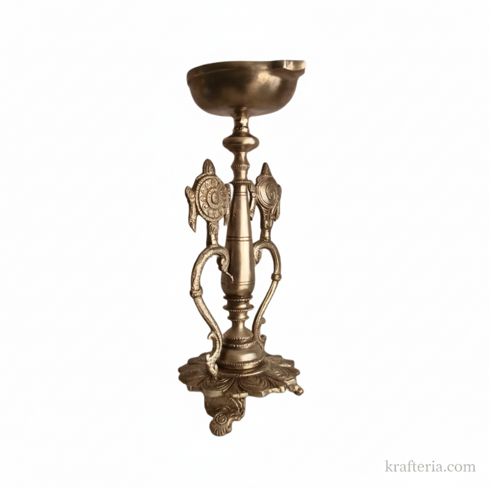 Sacred brass Vishnu lamp with conch and discus on pedestal, an altar diya.