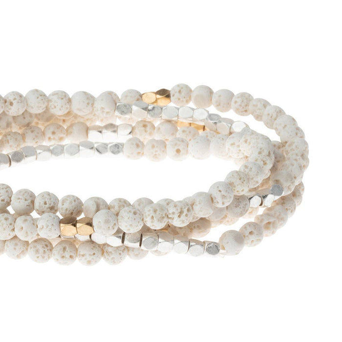 White beaded bracelet with gold accents on a white background